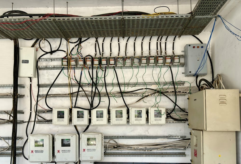休日の工場内でピロットランプが点灯したままの配電盤群